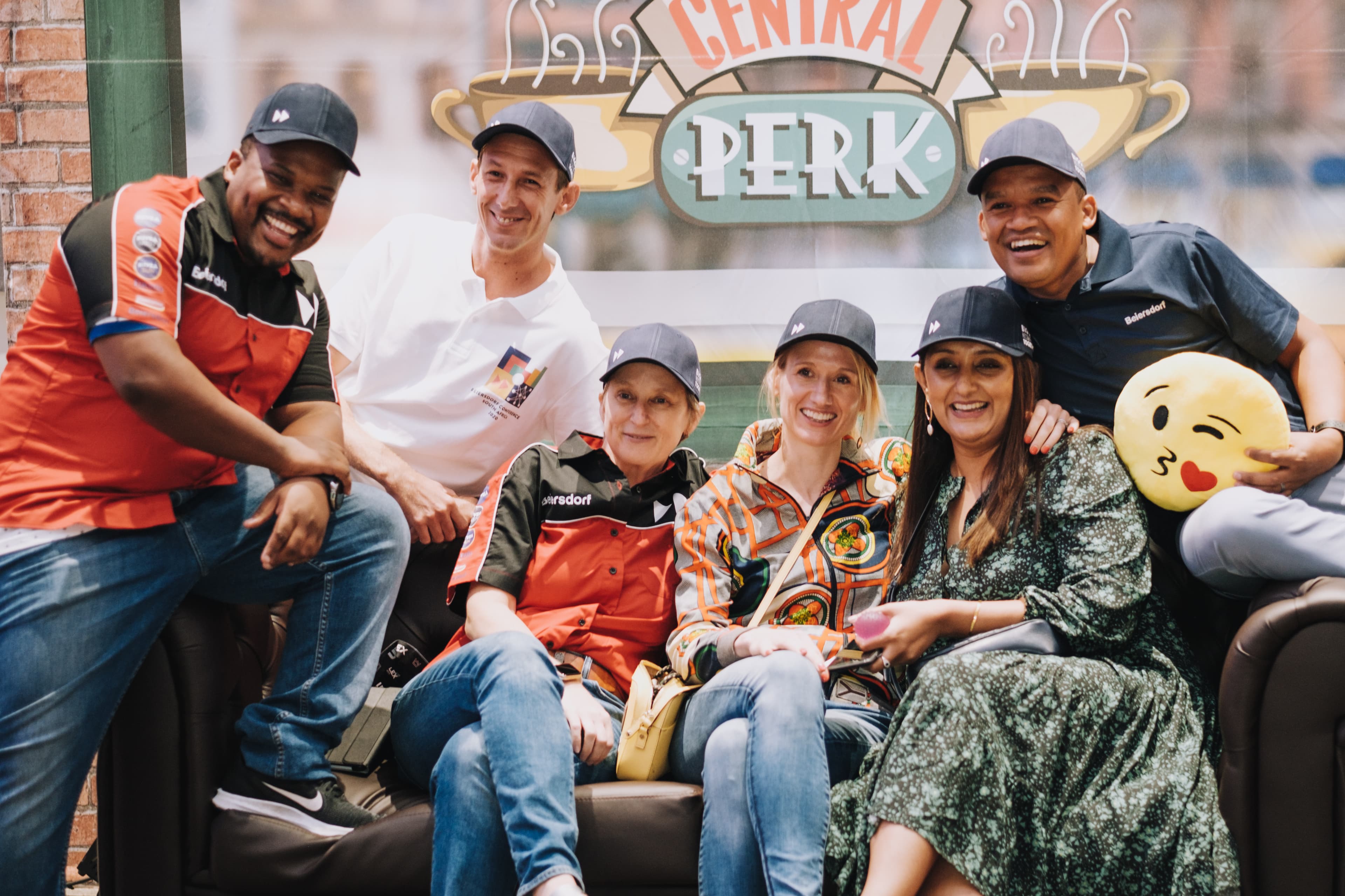 Beiersdorf South Africa team members seated together in branded caps during an internal brand experience.